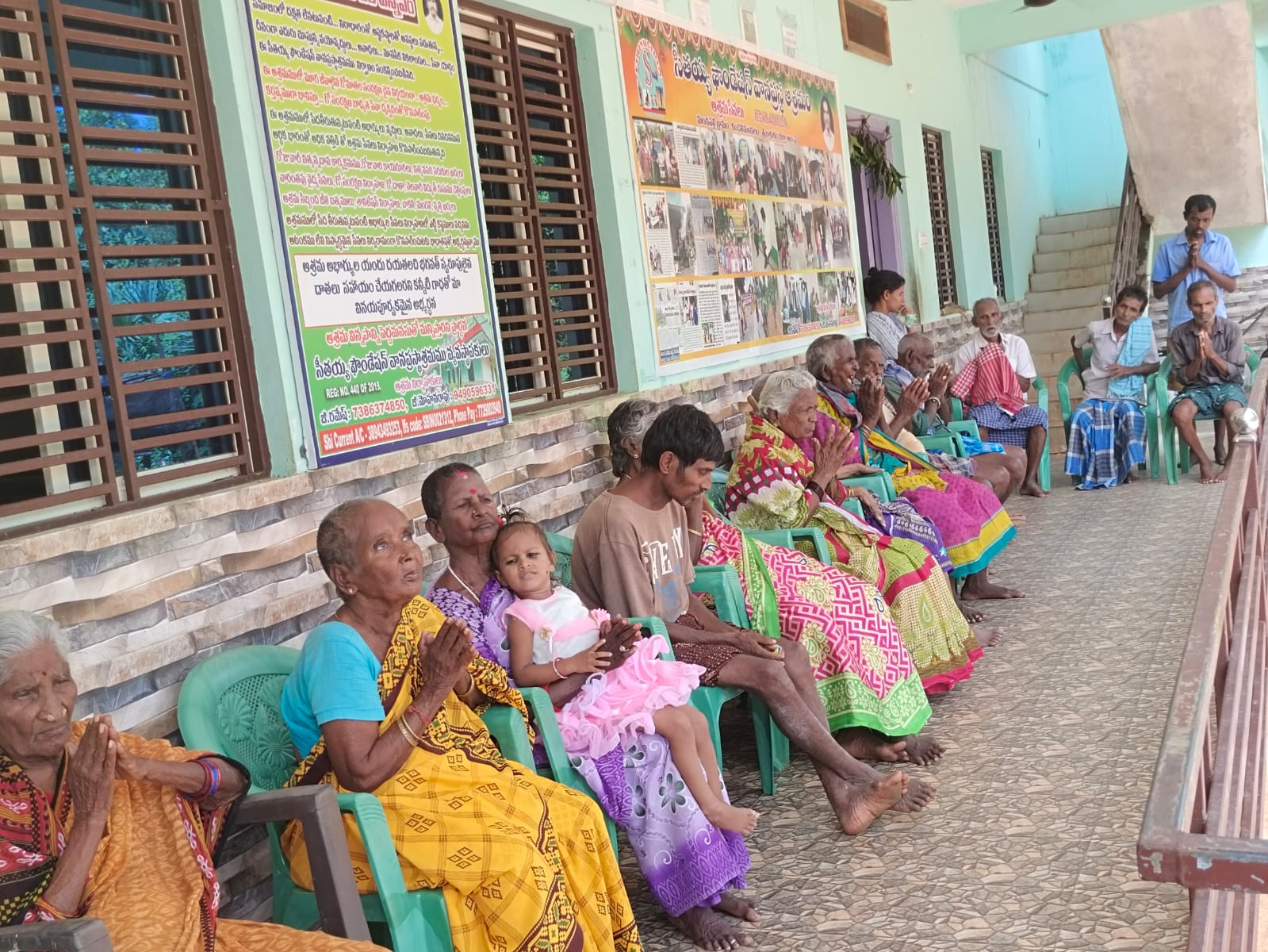 Residents seated along the ashram corridor